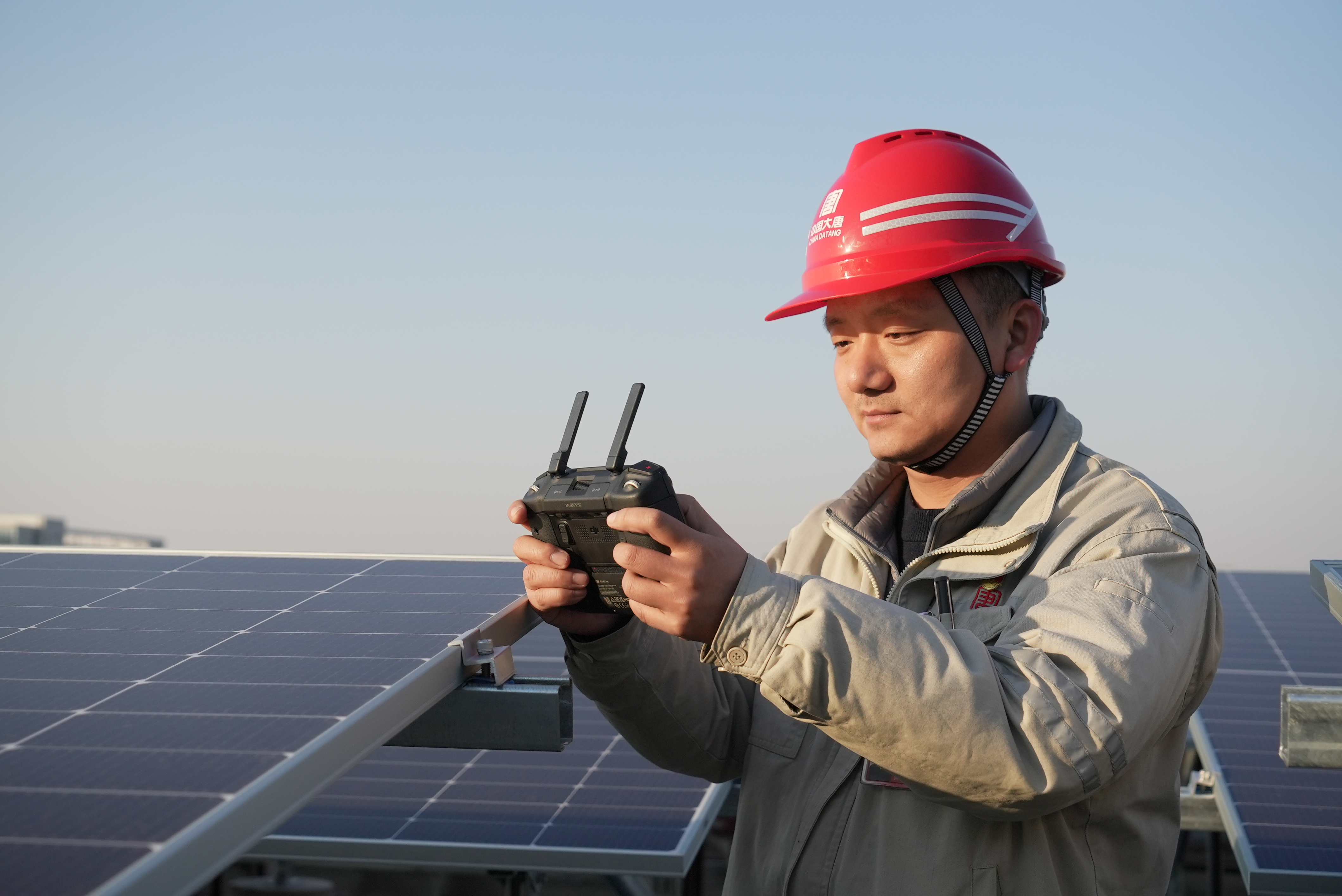 1716775313561097082.jpg 3.黄鹏飞使用无人机察看光伏建设现场.jpg